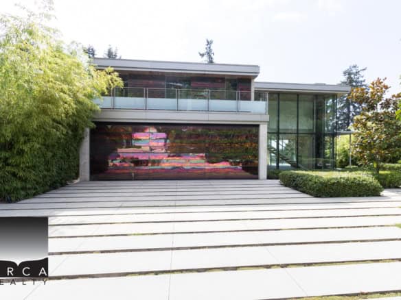 Modern luxury home with sleek design, expansive glass windows, landscaped yard, and contemporary architecture, showcasing upscale properties available through Orca Realty Inc. in Vancouver.