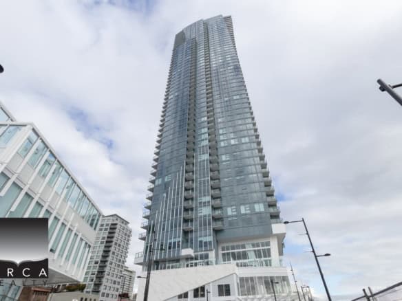 Contemporary high-rise residential building in downtown Vancouver with sleek glass exterior and modern design. Prime location offers stunning city views and luxury condo living.