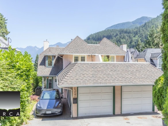 Spacious multi-storey house with a two-car garage, surrounded by lush greenery and mountain views, ideal for Vancouver area real estate market.