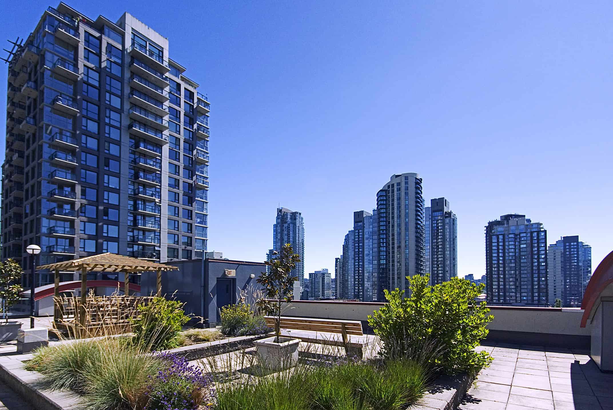 042 Modern high-rise condo buildings in Vancouver, BC, showcasing luxury urban living with rooftop gardens and outdoor seating areas, ideal for those interested in Vancouver real estate and condos for sale.