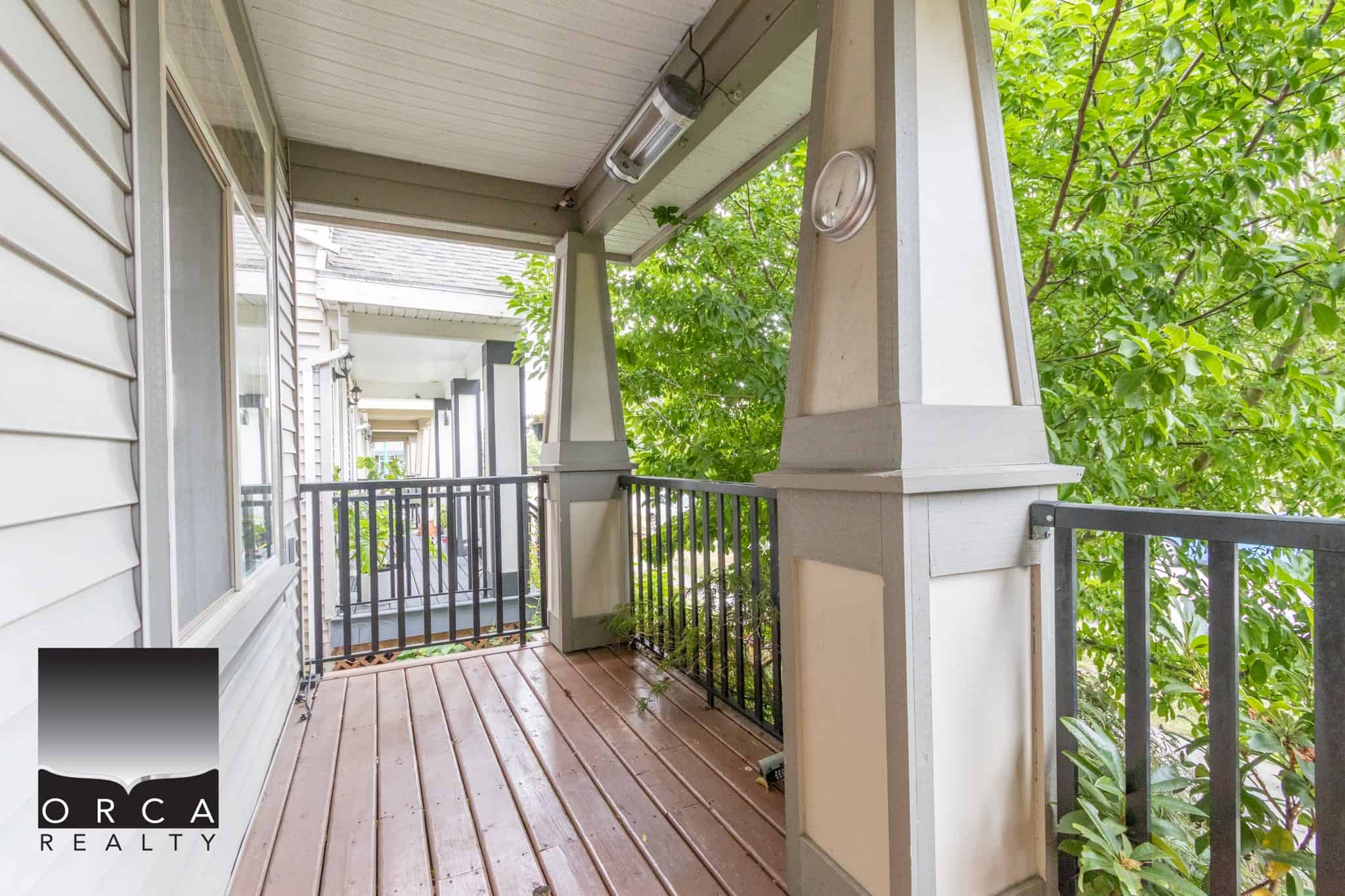 Spacious balcony with wooden flooring and lush greenery, ideal for relaxing outdoor living in a well-maintained residential property.