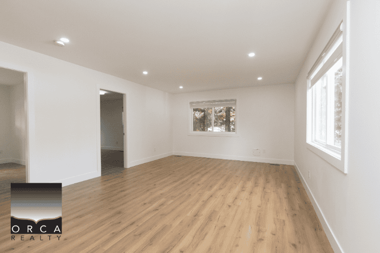 Bright, spacious living room with hardwood flooring and large windows in a modern home - ideal for real estate listings and property sales in Vancouver.