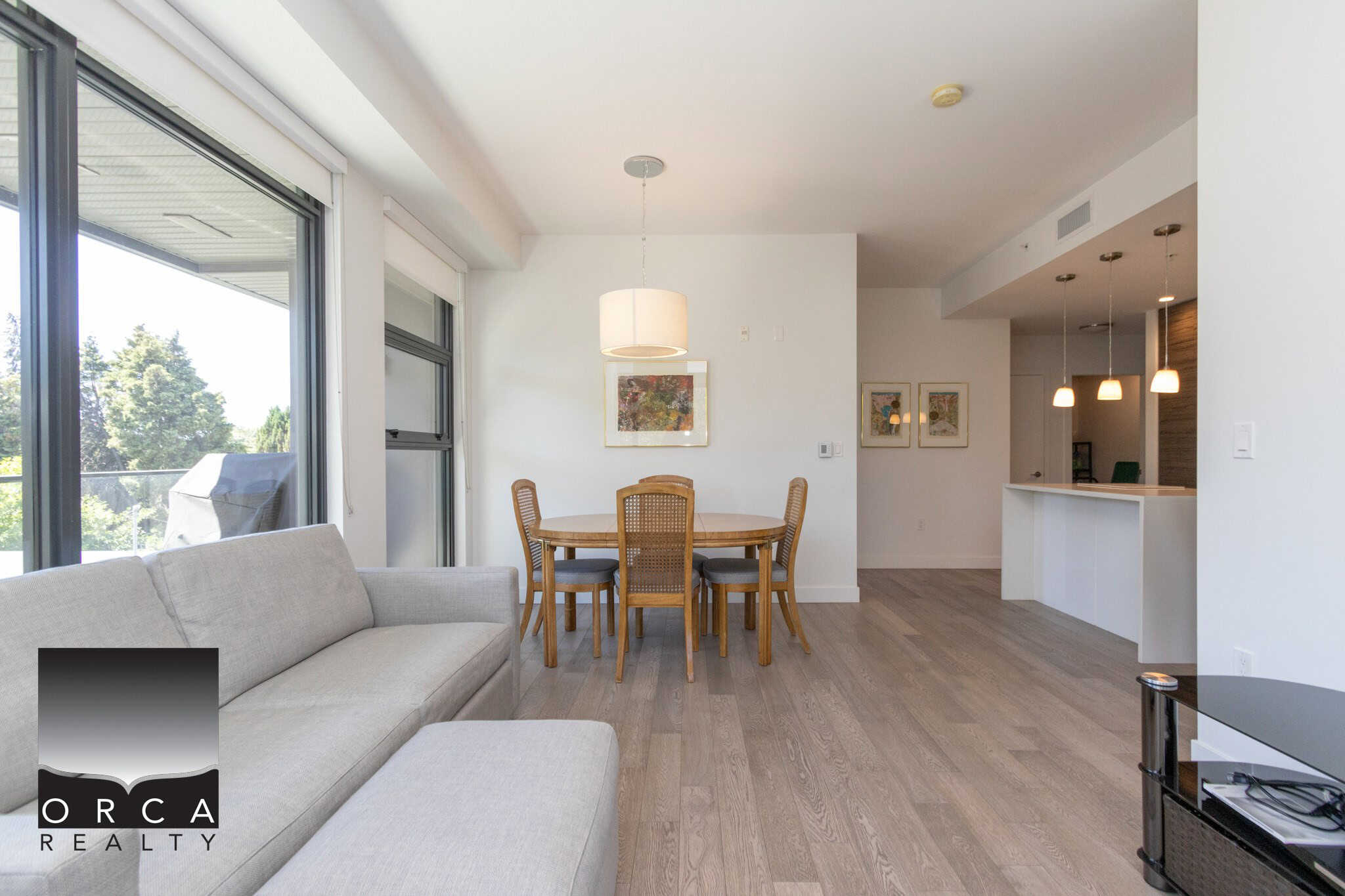 Bright, open-concept living and dining area in a modern Vancouver property, featuring large windows, hardwood floors, and contemporary decor for luxurious real estate living.