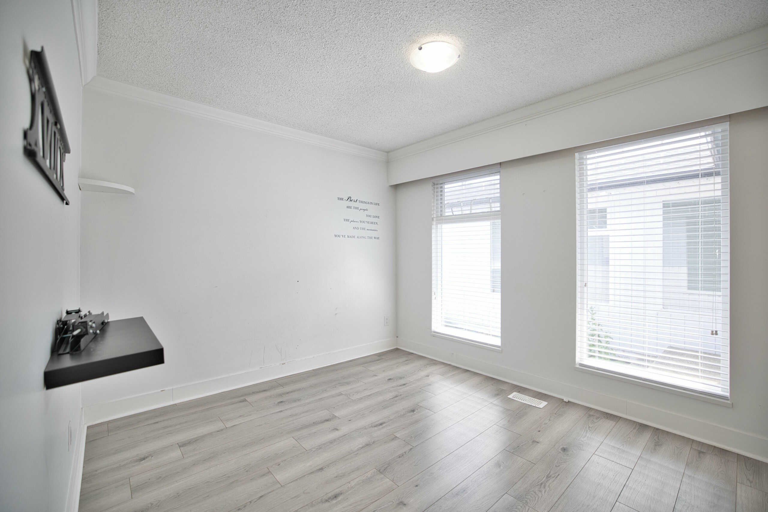 Bright, spacious living room with large windows, natural light, modern flooring, and neutral decor; ideal for Vancouver-area homebuyers seeking comfortable and stylish real estate options.