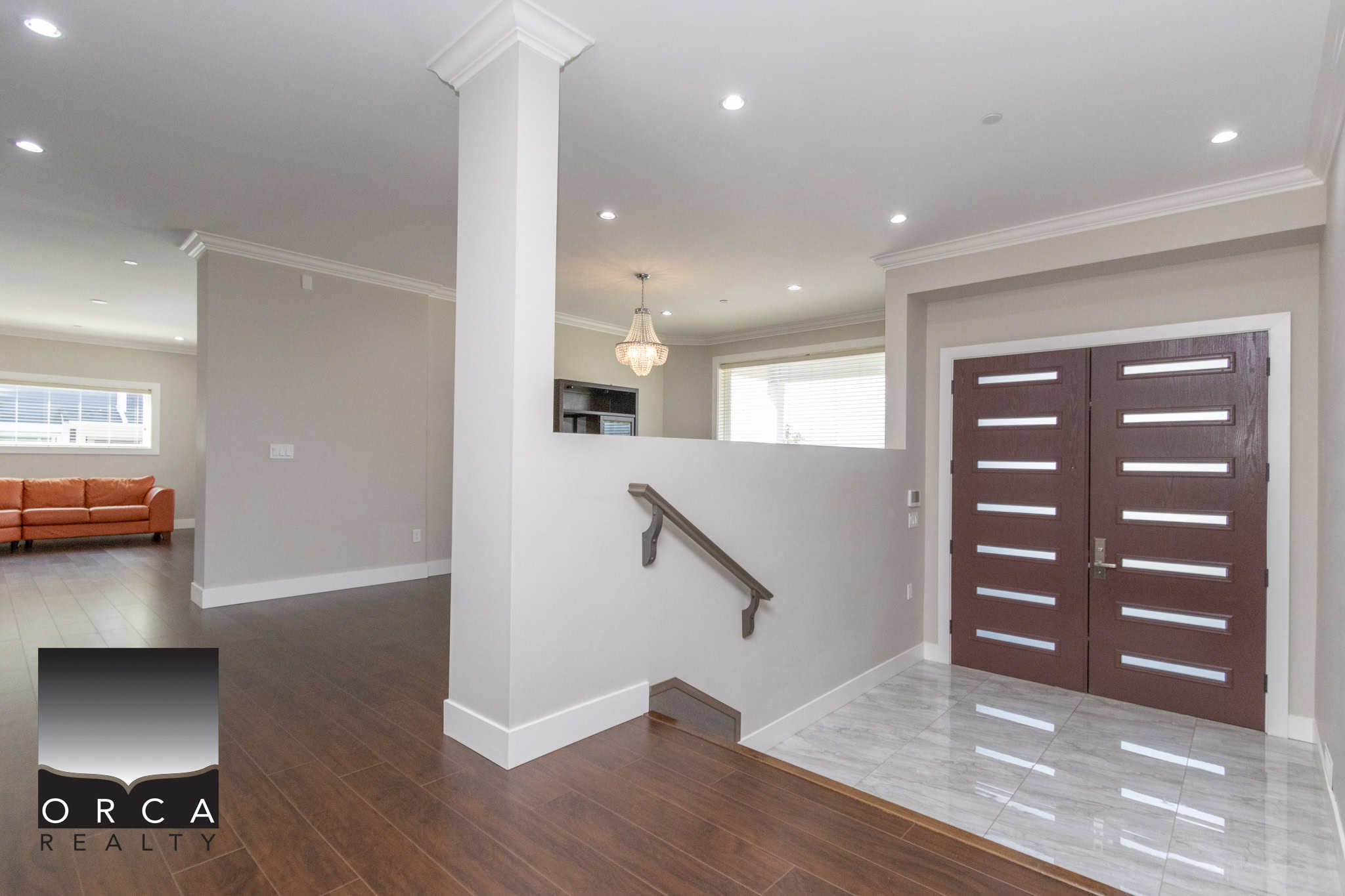 Modern contemporary home interior with entryway, stylish front door, hardwood flooring, and neutral wall colors, showcasing elegant residential design.