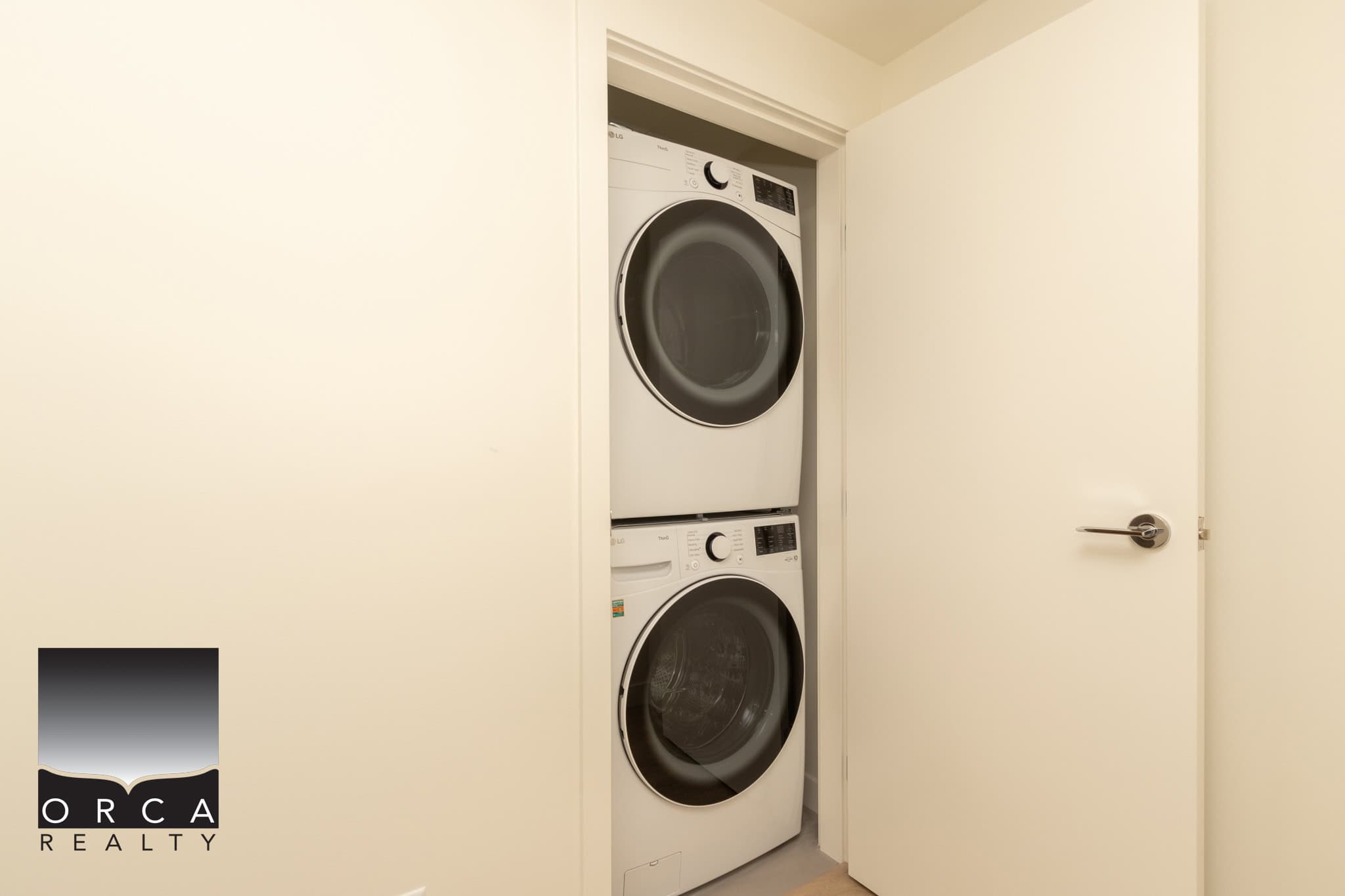 Stacked washer and dryer unit inside a laundry closet, modern appliances for convenient home living, in a clean, well-maintained property.