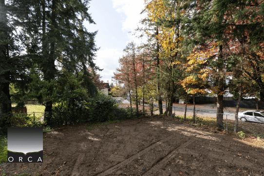 Vacant residential lot surrounded by mature trees and fencing, ideal for building your dream home in a peaceful neighbourhood in Ontario, Canada.