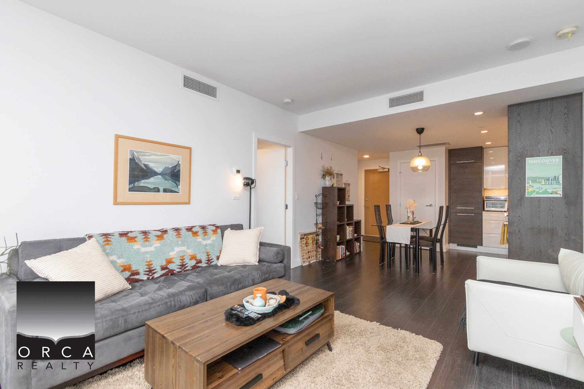 Cozy modern living room in Vancouver apartment with stylish furniture, dark hardwood floors, and open-concept design, perfect for Vancouver real estate buyers seeking stylish downtown condos.