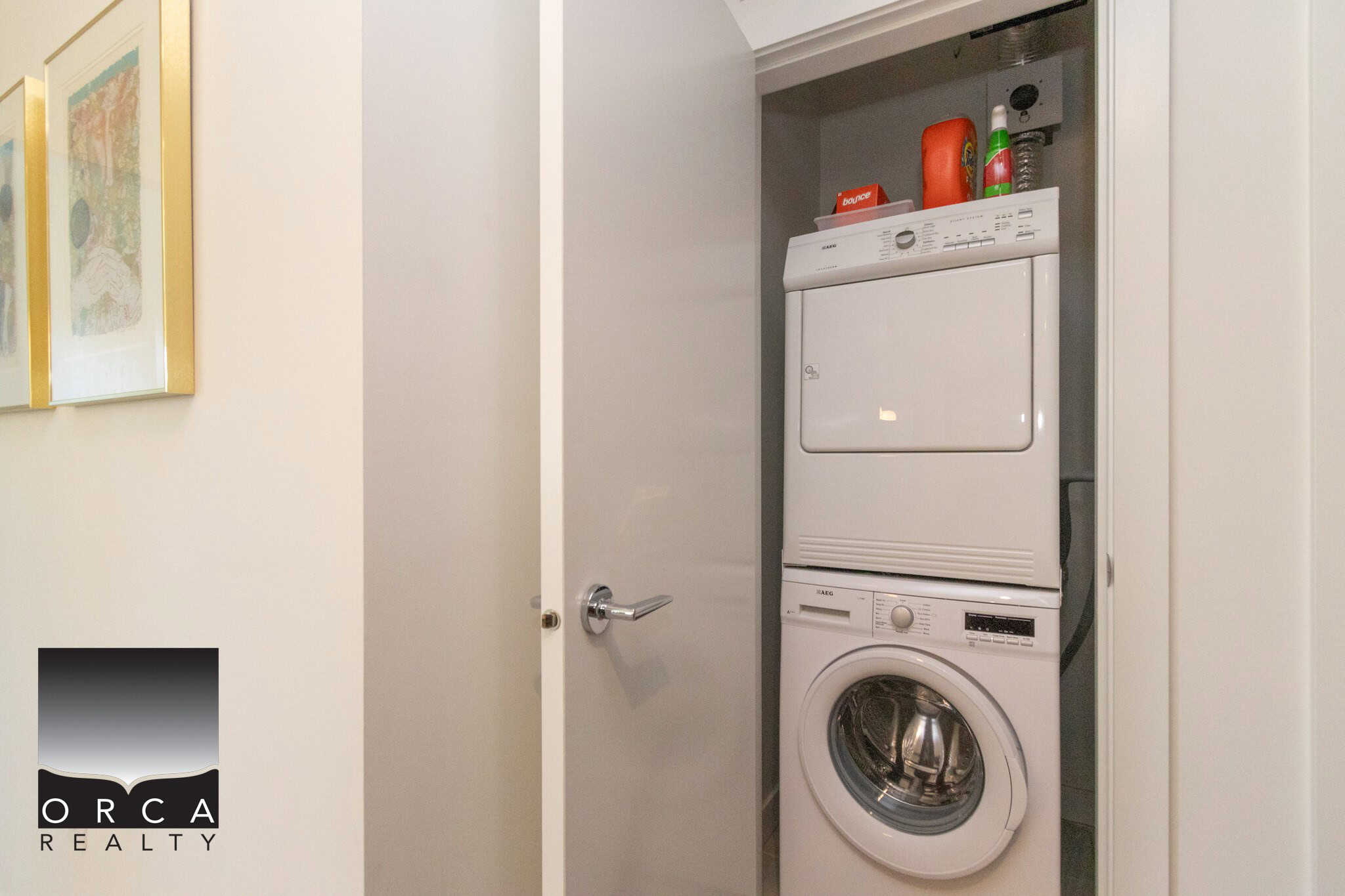 Stacked washer and dryer in a small laundry closet in a residential home. Compact laundry appliances perfect for Vancouver real estate properties.