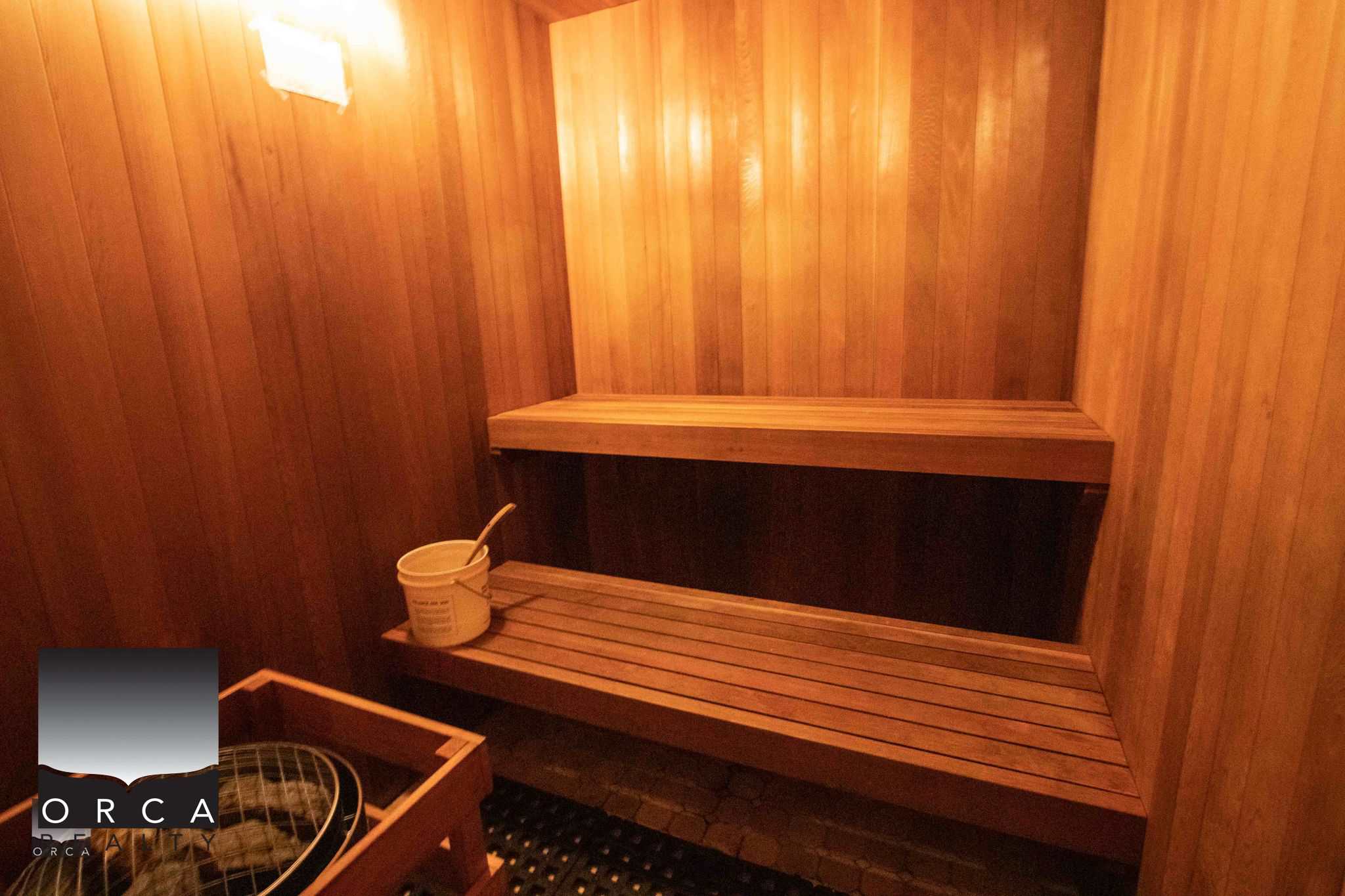 Heated wooden sauna interior showcasing traditional wood paneling and seating, perfect for relaxation and wellness in a luxury property managed by Orca Realty Inc.