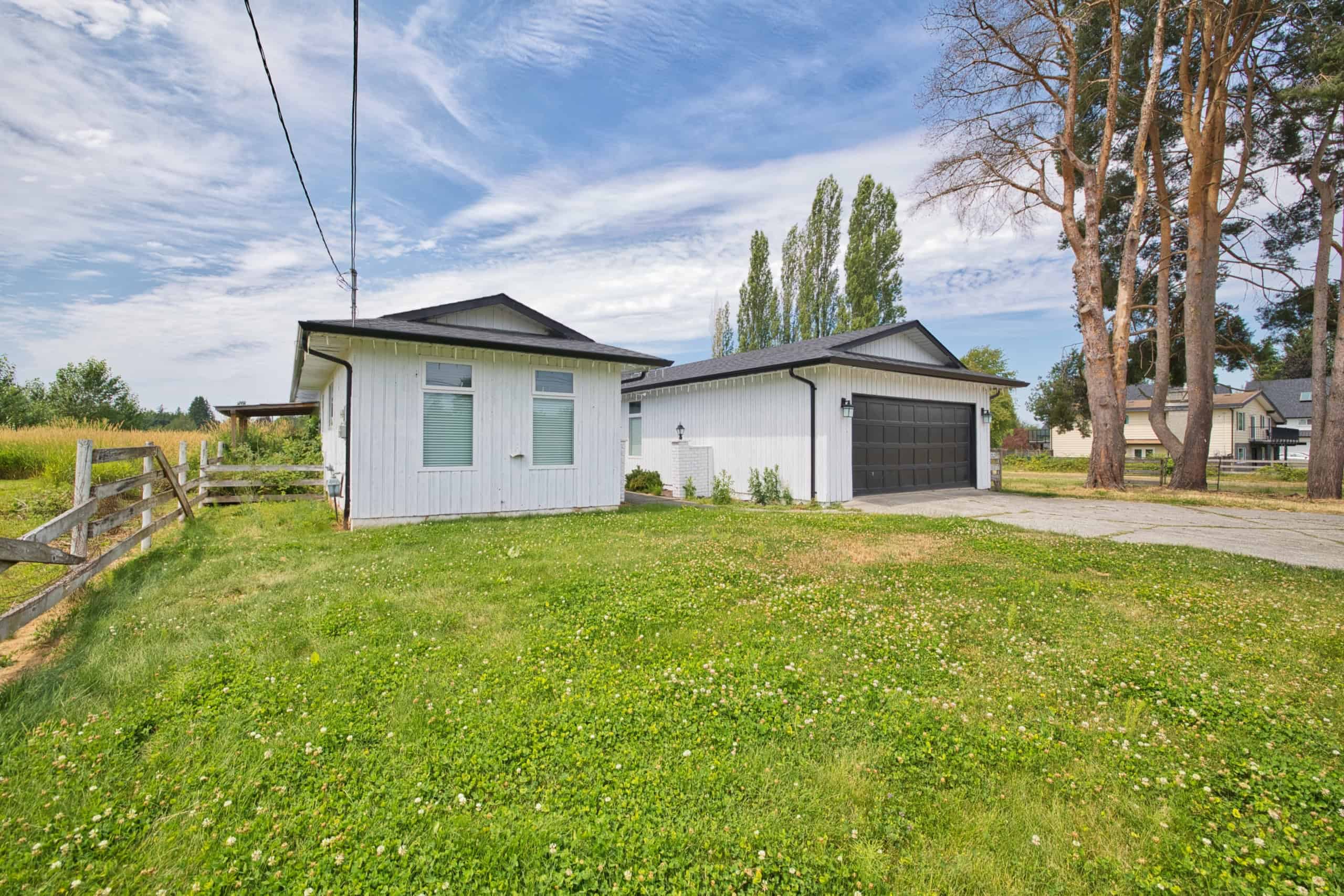 Spacious backyard with a detached garage and lush green lawn, ideal for family living and outdoor activities in a charming residential neighborhood.