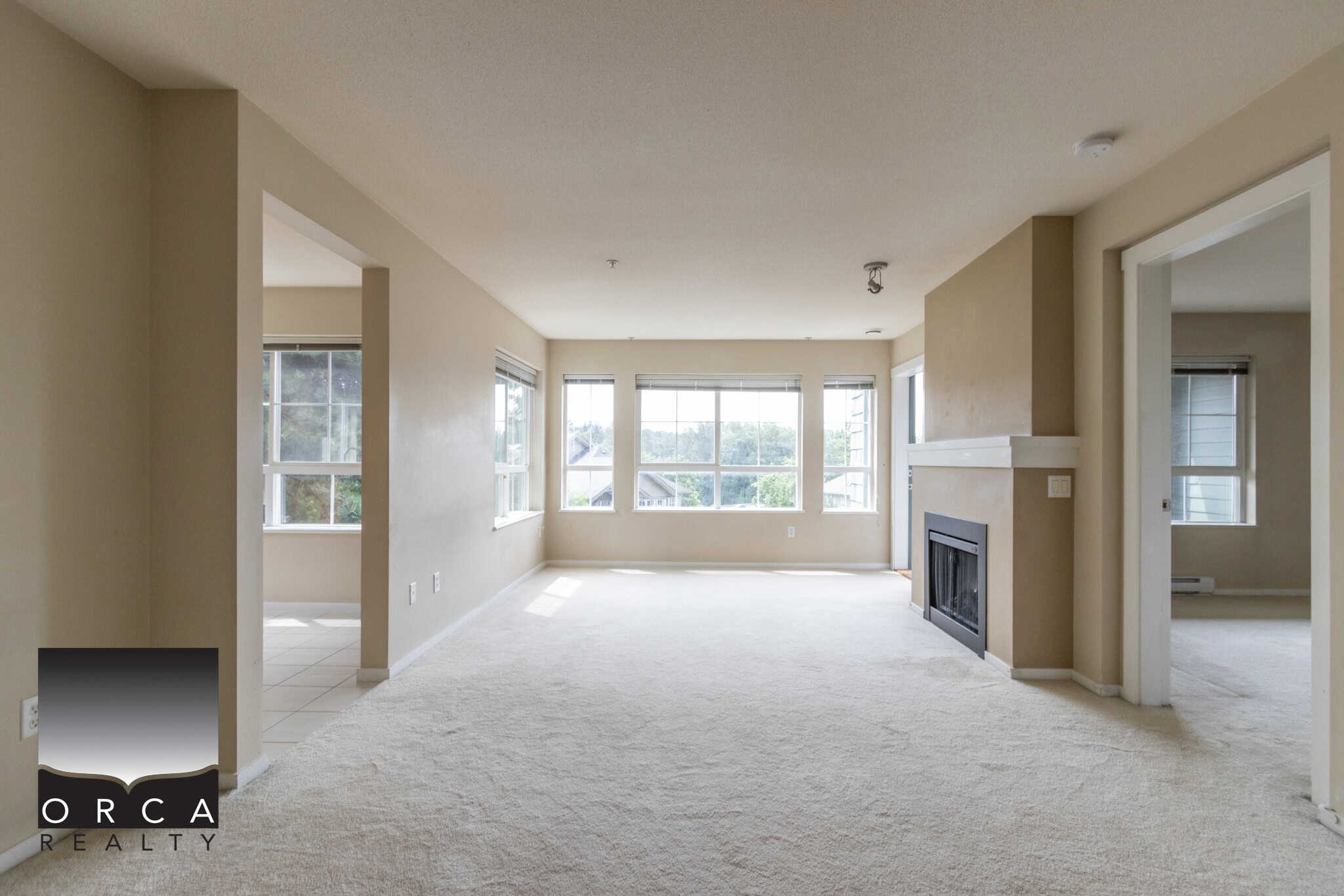 Spacious living room with large windows and fireplace, bright interior, ideal for real estate listings in Vancouver area.