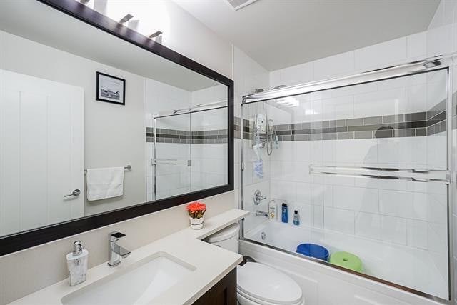 Modern bathroom with white tiles, glass shower enclosure, and contemporary fixtures, perfect for Vancouver real estate listings and home renovation projects.