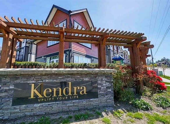 Contemporary multi-family residential building with landscaped garden and Kendra sign, in a vibrant Vancouver neighbourhood.