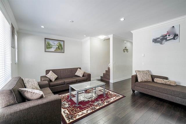 Modern living room with white walls, dark hardwood floors, and stylish furniture, ideal for Toronto real estate listings.