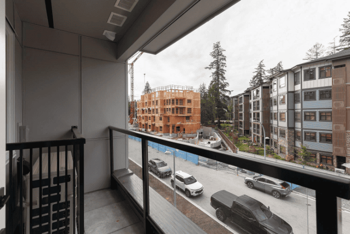 Modern balcony view overlooking new construction residential buildings in a Canadian urban area, ideal for real estate development and property investment in Vancouver.