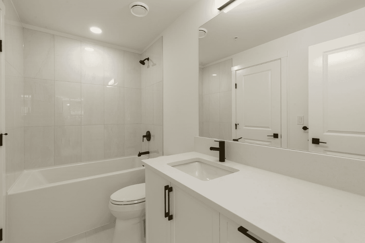 262951450-39d68392-7ea6-4832-9469-81b230ebb3e9 Modern white bathroom with bathtub, sleek vanity, and black fixtures, showcasing contemporary interior design options for Vancouver and BC real estate from Orca Realty Inc.