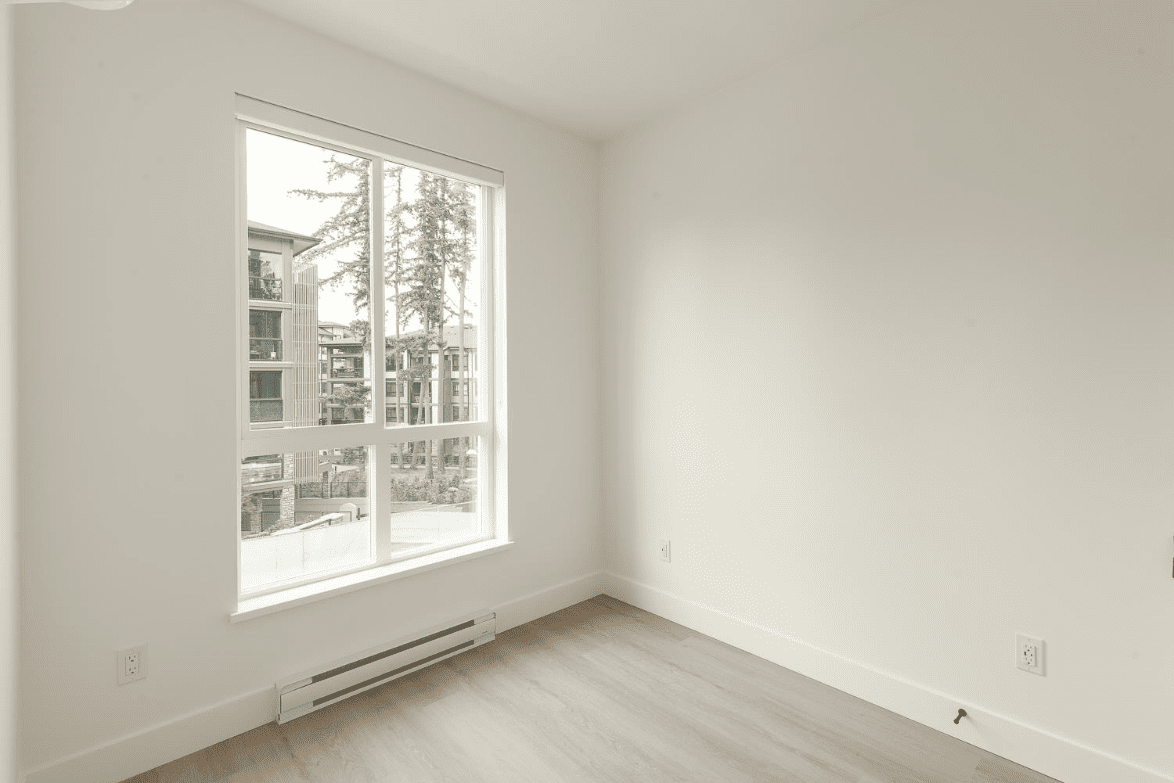 262951450-5af56658-3198-4dcc-9d7a-3abd6ce930d4 Bright empty room with large window showcasing natural light and modern condo interior; ideal for Vancouver area real estate listings.