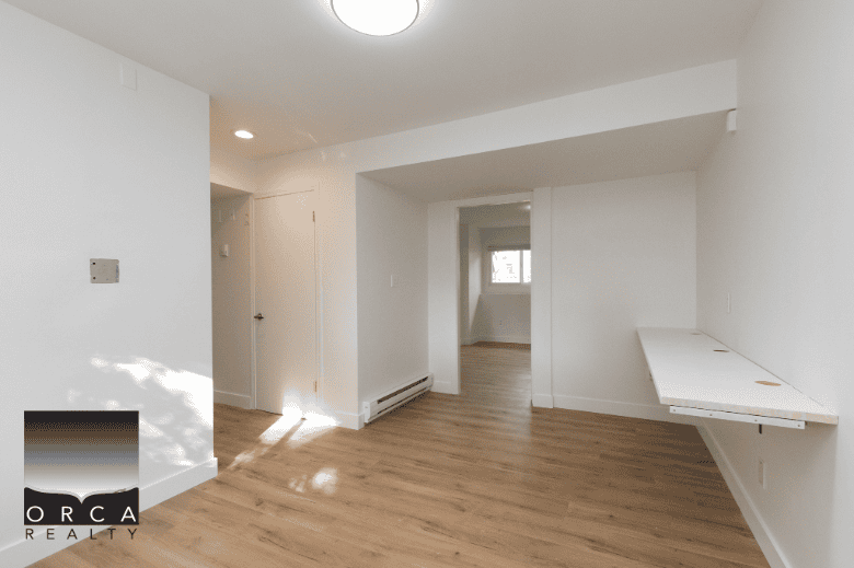 Bright modern interior of a Vancouver apartment listing by Orca Realty Inc., featuring clean white walls, hardwood flooring, and natural light, ideal for prospective homebuyers seeking a cozy and stylish residence.