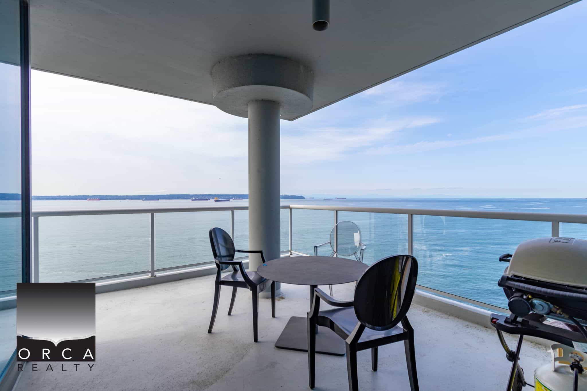 Stunning ocean view balcony with modern outdoor furniture and glass railing, offering a perfect setting to enjoy the Vancouver waterfront and ocean scenery in local luxury condos.