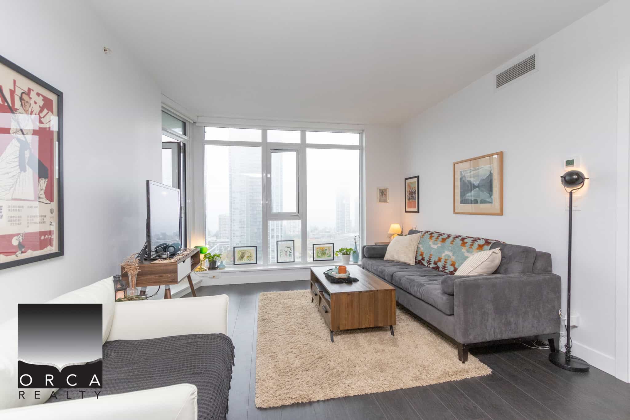 Bright urban living room with large windows, modern decor, and city skyline view - ideal for Vancouver condos and real estate investments.