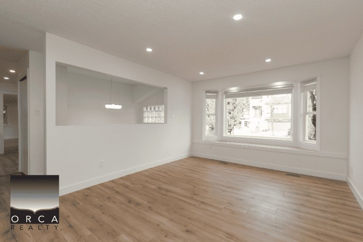 Bright and spacious living room with large windows and natural light in Victoria, BC, featuring hardwood floors and modern interior design. Ideal for comfortable family living and entertaining.
