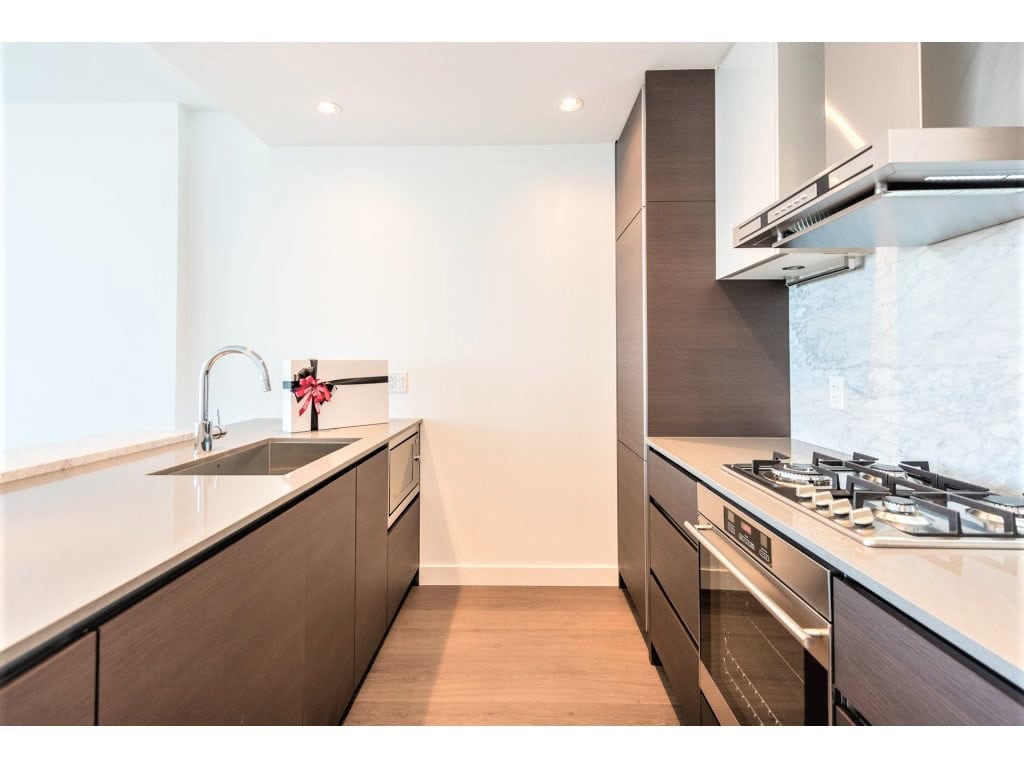 Modern kitchen in Vancouver apartment, showcasing sleek cabinetry, stainless steel appliances, and minimalist design, perfect for luxury condo living and real estate in the area.