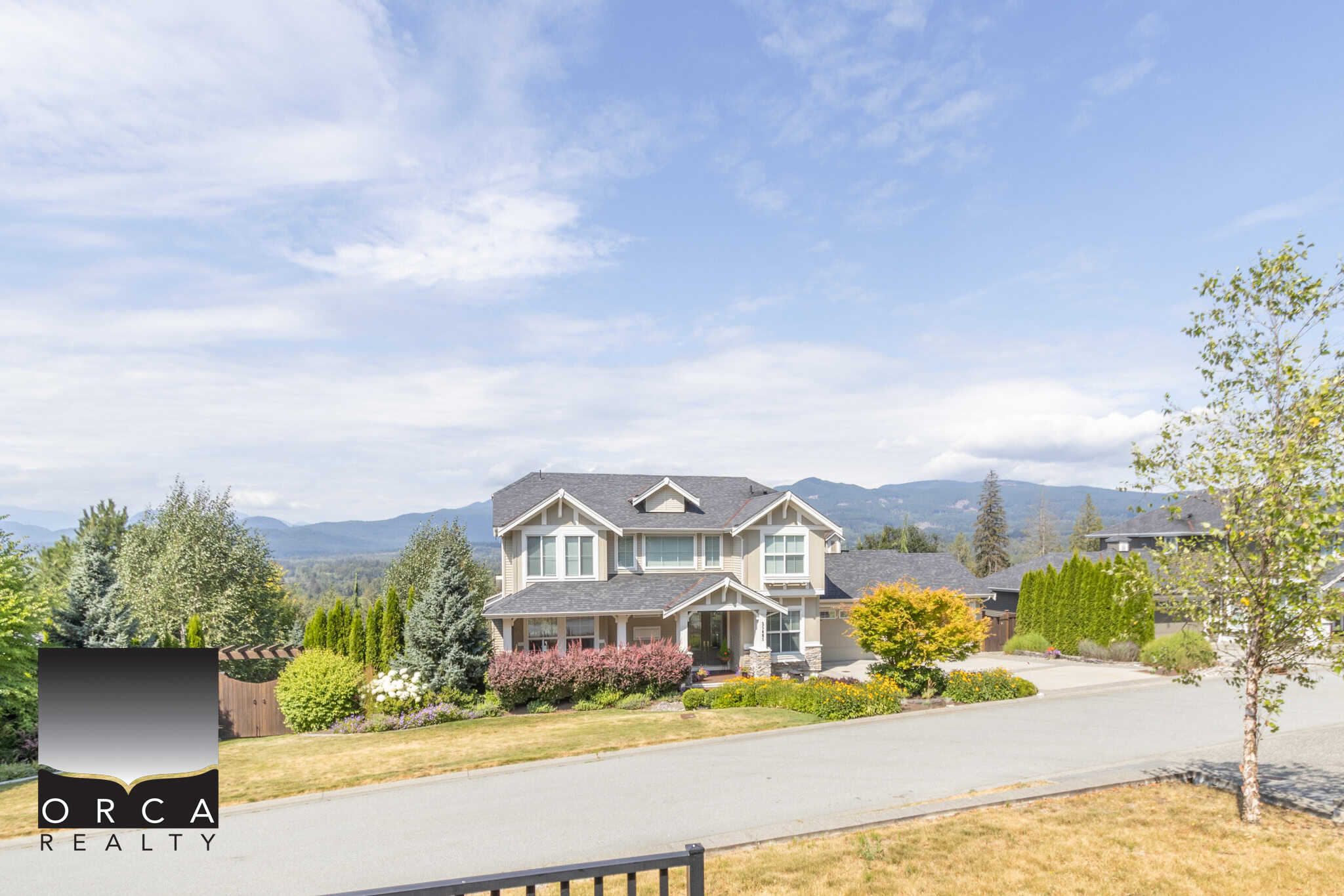 Spacious modern family home in a scenic neighbourhood with mountain views, surrounded by lush landscaping and greenery, showcasing Vancouver Island real estate opportunities.