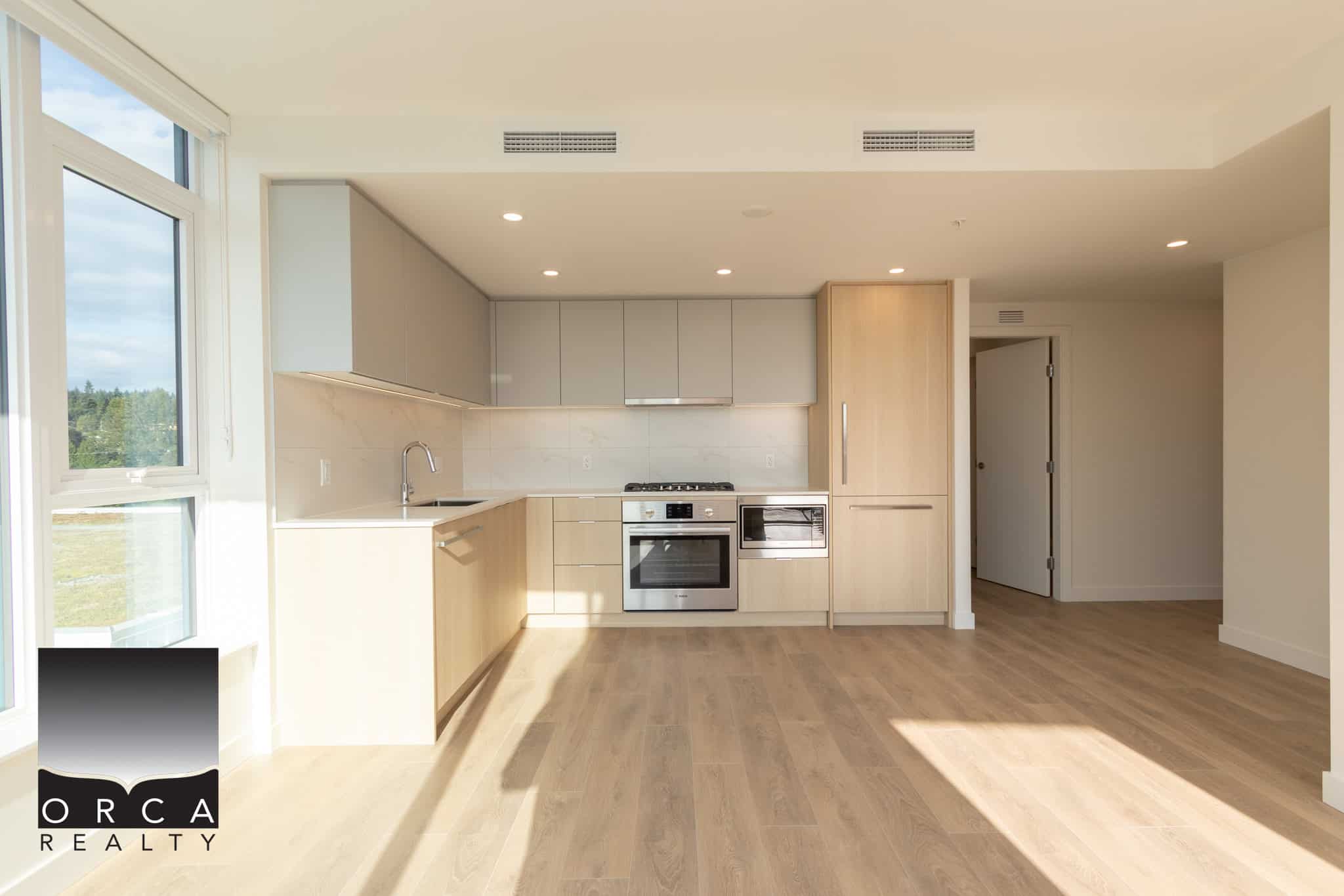Modern open-concept kitchen with natural light, stainless steel appliances, and contemporary cabinetry, ideal for Vancouver-area real estate buyers.