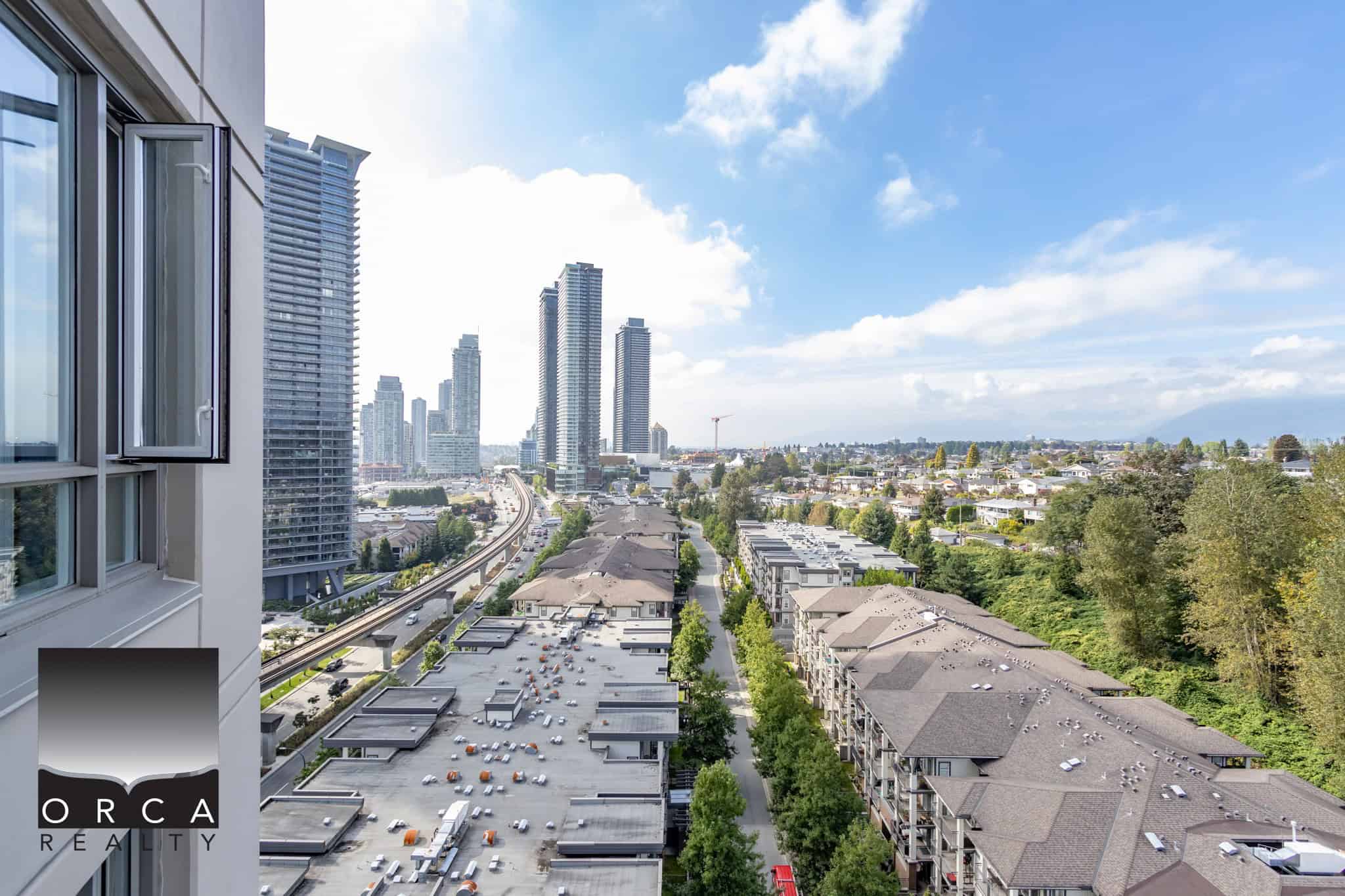 Modern urban view from a high-rise apartment showcasing Vancouver's skyline, with nearby residential and commercial buildings, emphasizing luxury condo living and Vancouver real estate by Orca Realty.