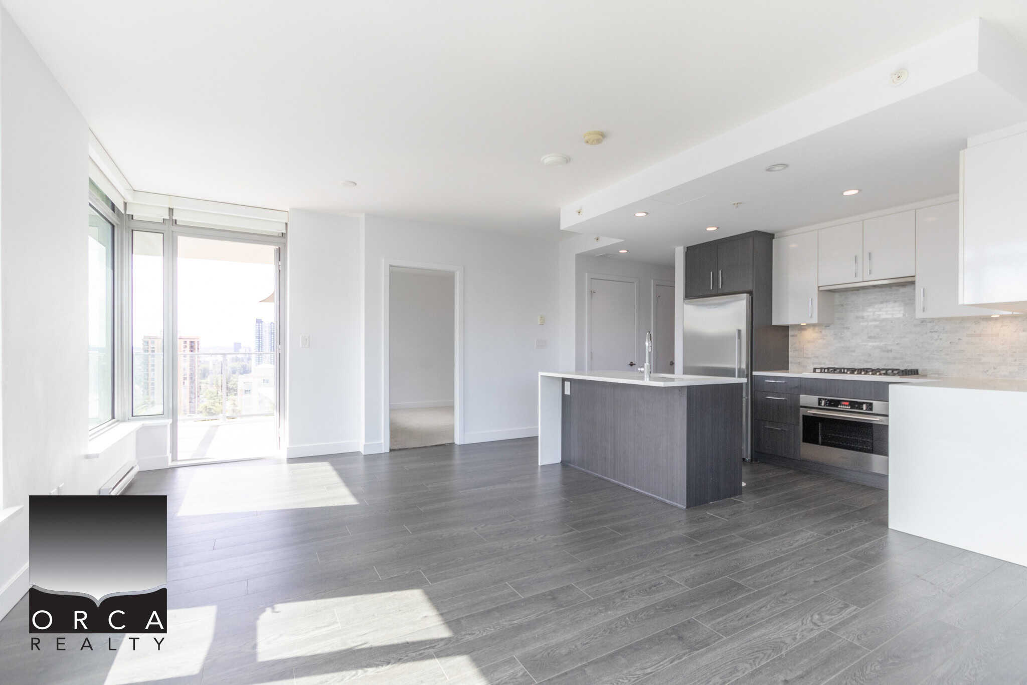 Modern open-concept kitchen and living space in a new condo, featuring sleek cabinetry, stainless steel appliances, and hardwood flooring, perfect for urban living in Vancouver.