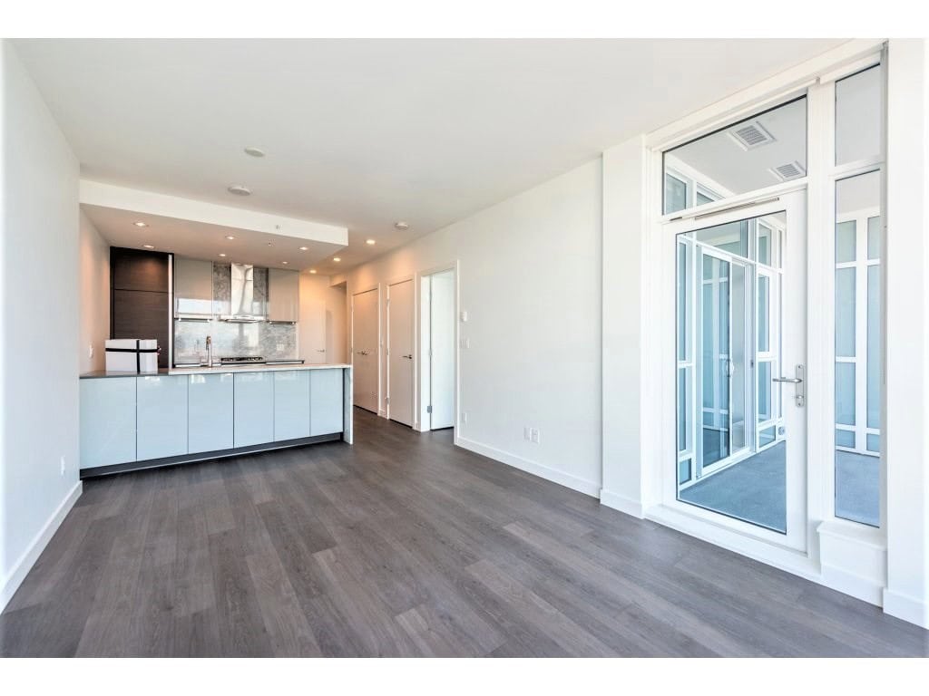 Modern open-concept kitchen and living space in a Vancouver-area condo, featuring large glass doors, contemporary cabinetry, and sleek finishes for stylish, comfortable city living.