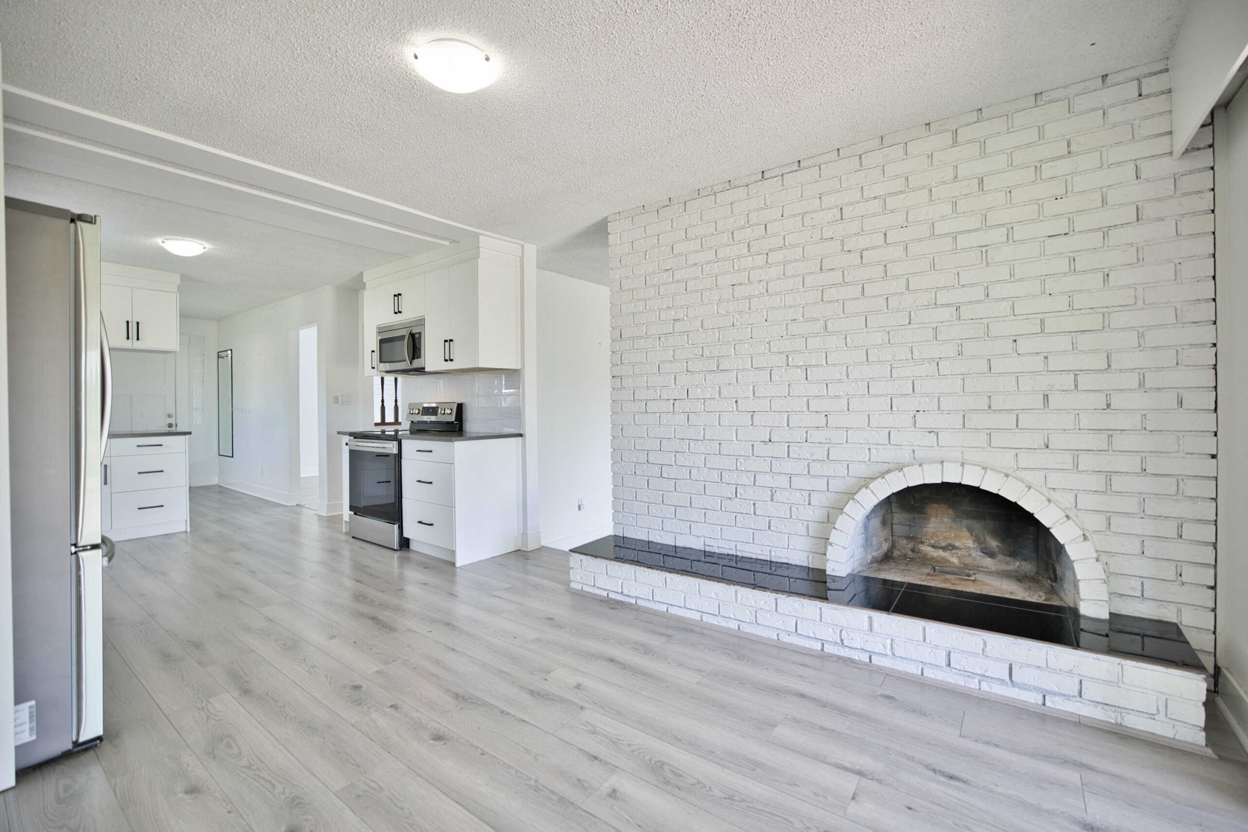 Modern kitchen with white cabinetry and stainless steel appliances in a contemporary home.