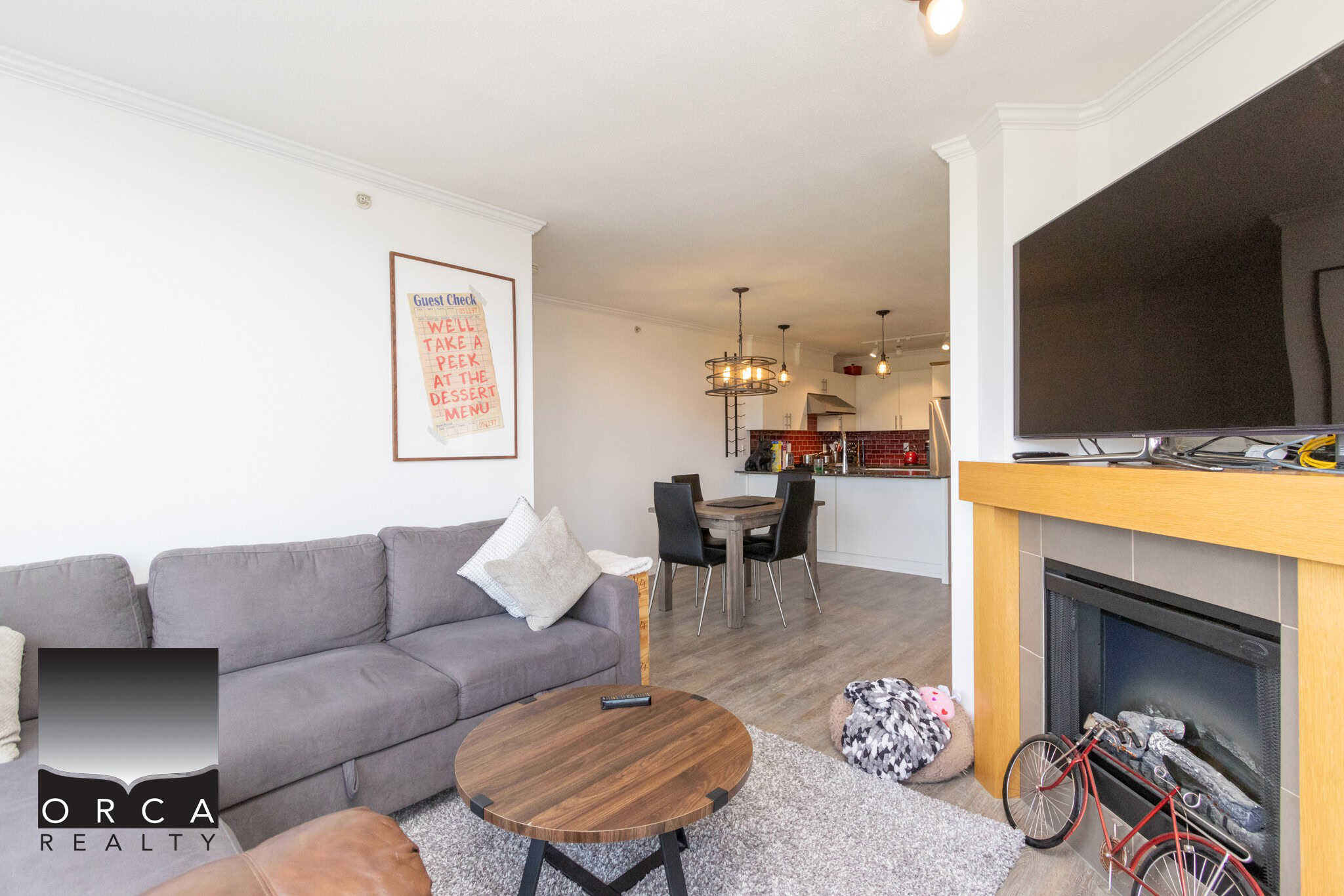 Cozy living room with modern decor, open-concept kitchen, and stylish dining area in a Vancouver property listed by Orca Realty Inc.