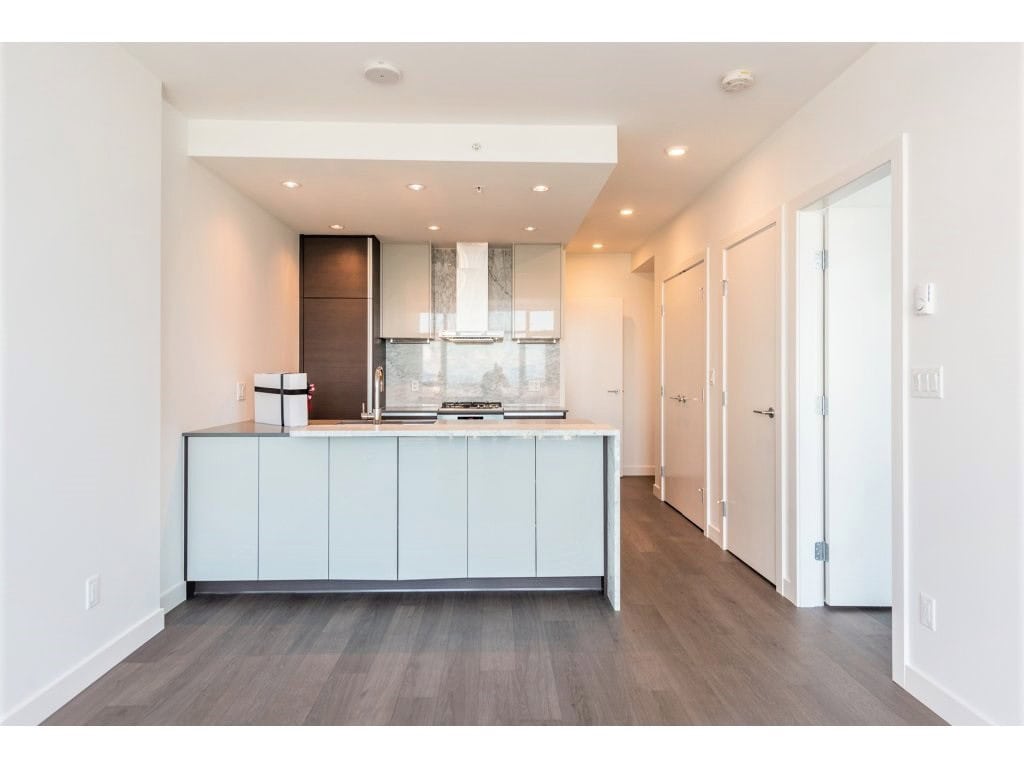 Modern minimalist kitchen with sleek white cabinetry and marble countertops, perfect for downtown Vancouver living – featured by Orca Realty Inc.