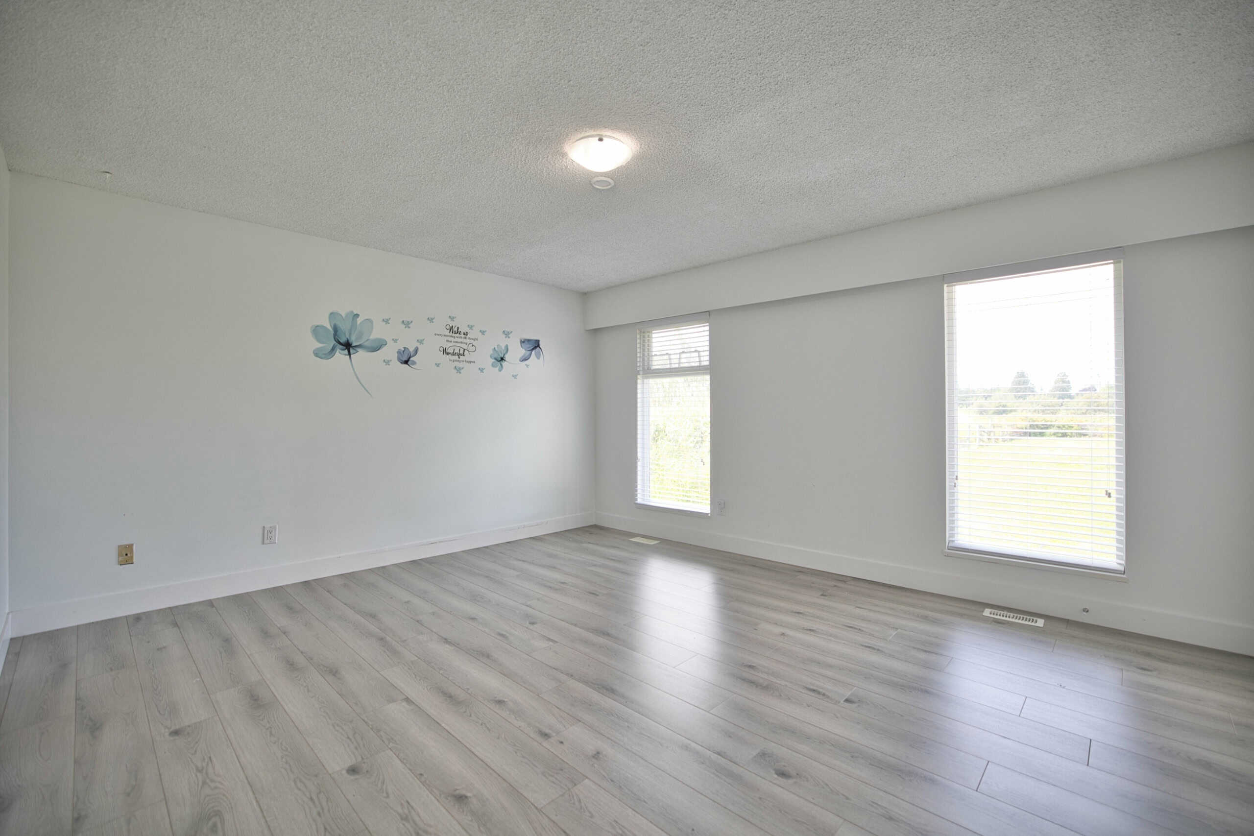 Bright and spacious living room with large windows, neutral decor, and light wood flooring, ideal for Vancouver properties listed by Orca Realty Inc.