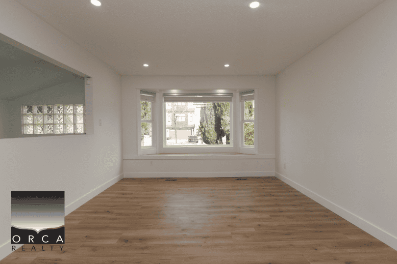 Bright spacious living room with large bay window, hardwood flooring, and natural light in a modern home listing in BC. Perfect for comfortable family living or entertaining guests.