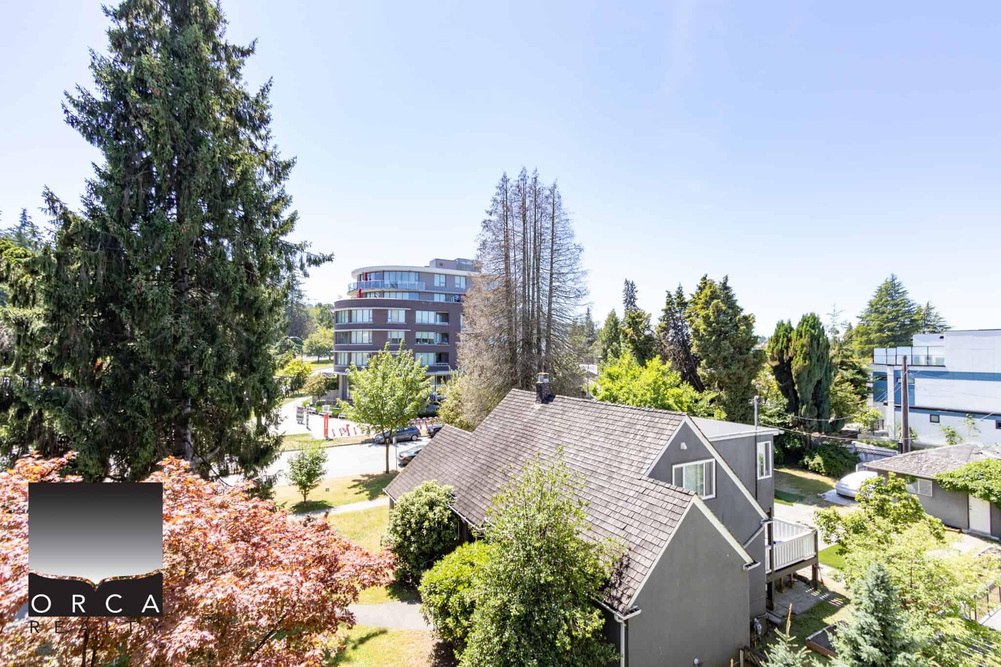 Lush suburban neighbourhood with a mix of single-family homes and modern condos, surrounded by mature trees and greenery, ideal for real estate investment and residential living in Victoria, BC.