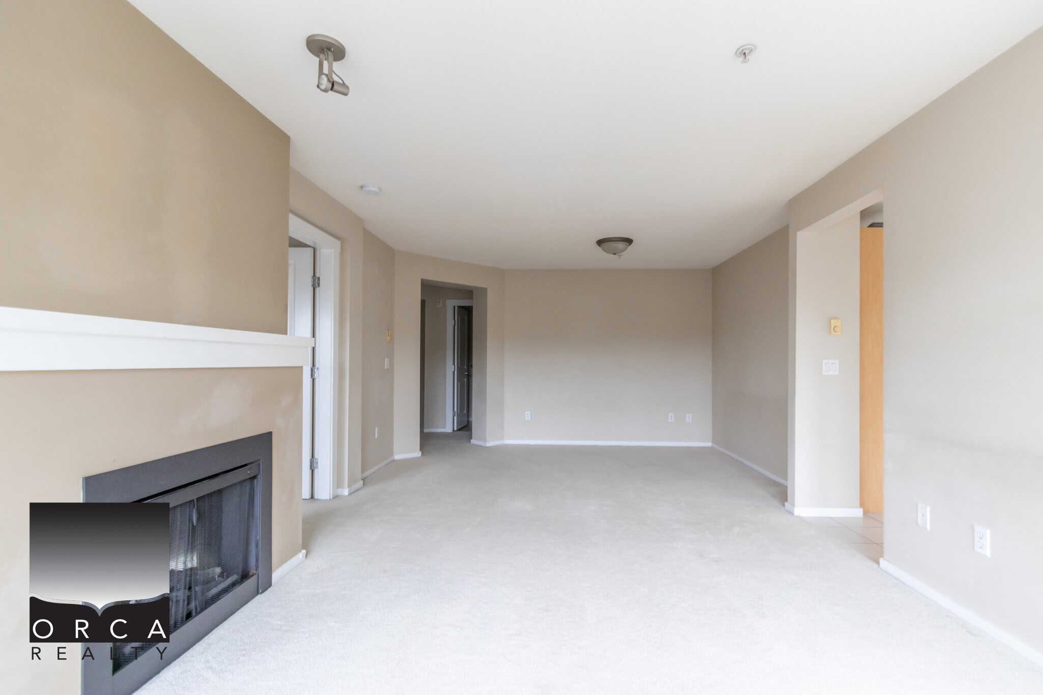 Bright spacious living room with neutral wall colours, a modern fireplace, and large windows, ideal for Vancouver property buyers and real estate investors.