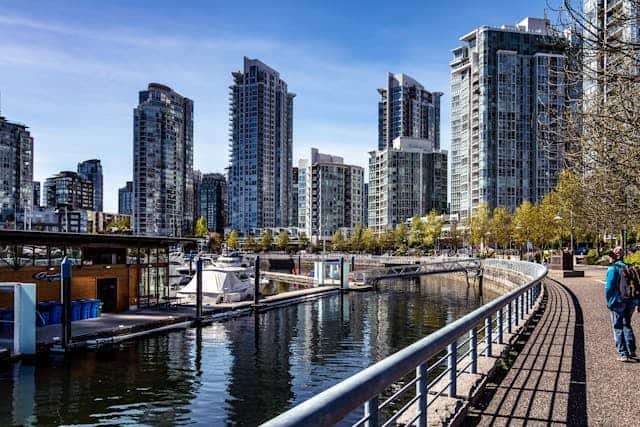 Old photo of waterfront high-rise condos in Vancouver, BC with marina and walking path, representing the vibrant real estate market and lifestyle opportunities offered by Orca Realty Inc.
