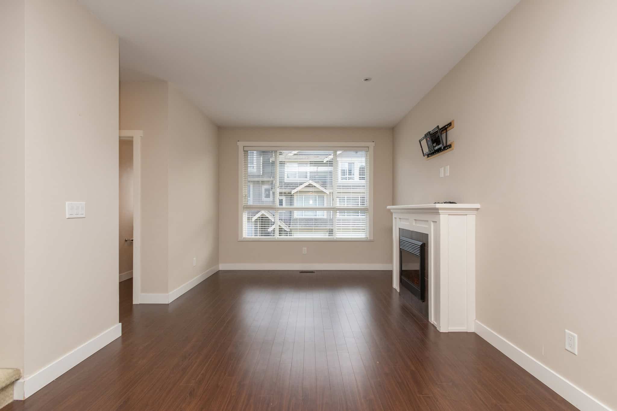 IMG_1771 Bright spacious living room with large window, hardwood floors, and modern fireplace - perfect for homebuyers seeking comfort in Vancouver area.