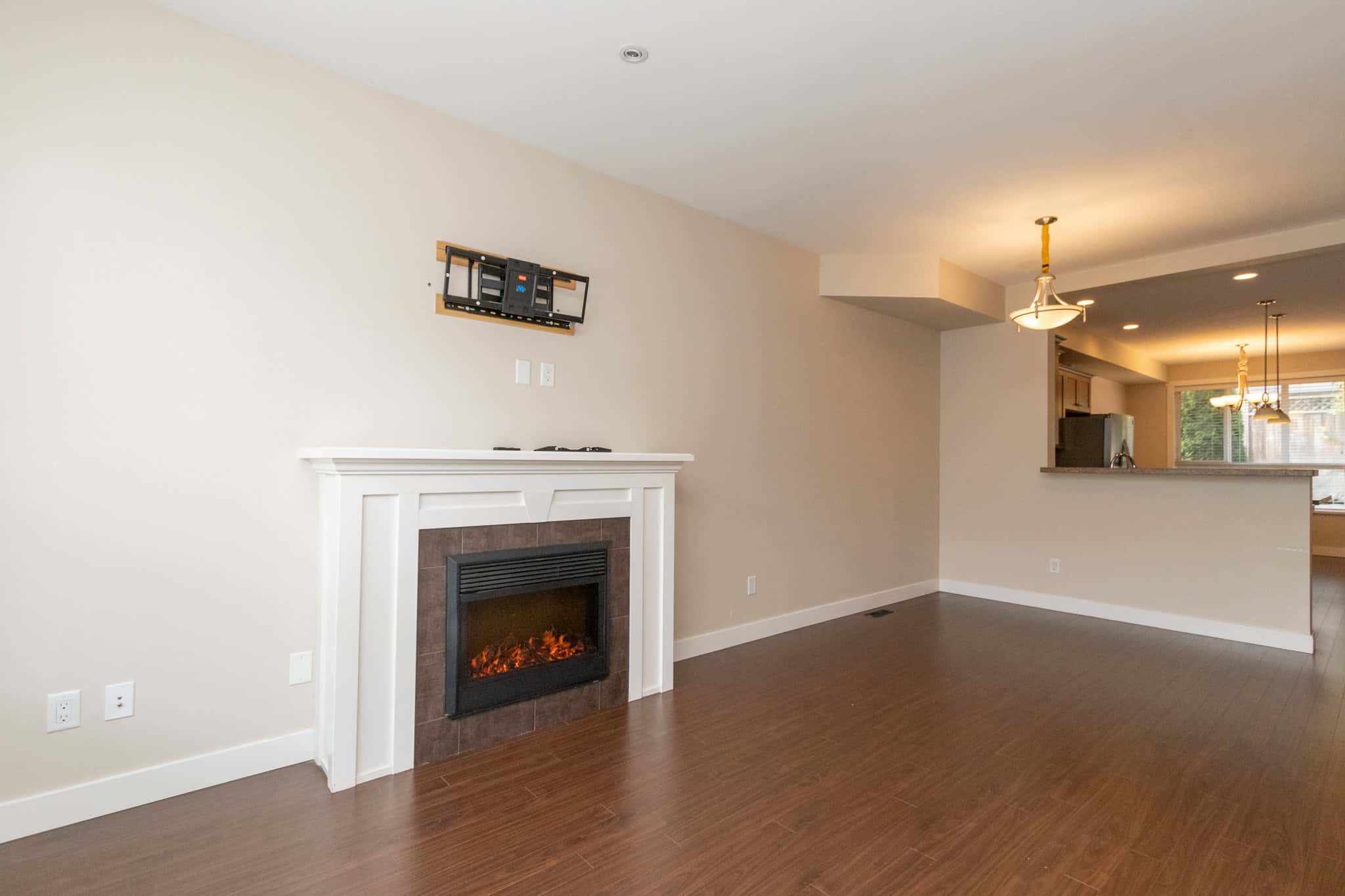 IMG_1777 Modern living room with fireplace and open-concept design, featuring neutral tones and hardwood flooring, ideal for real estate listings and home sales in BC.