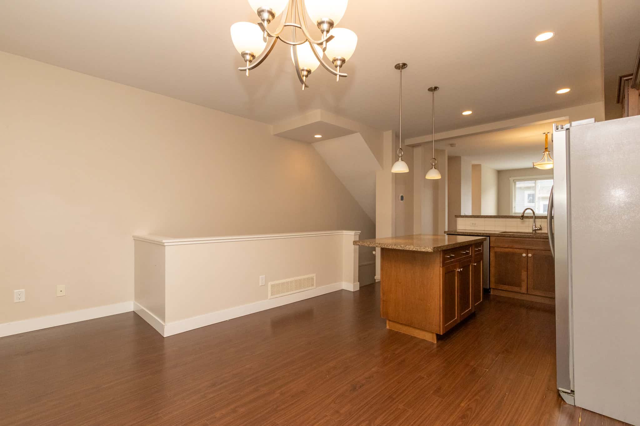 IMG_1798 Spacious open-concept kitchen and living area with hardwood flooring, modern lighting fixtures, and a cozy atmosphere, ideal for Vancouver Island real estate buyers.