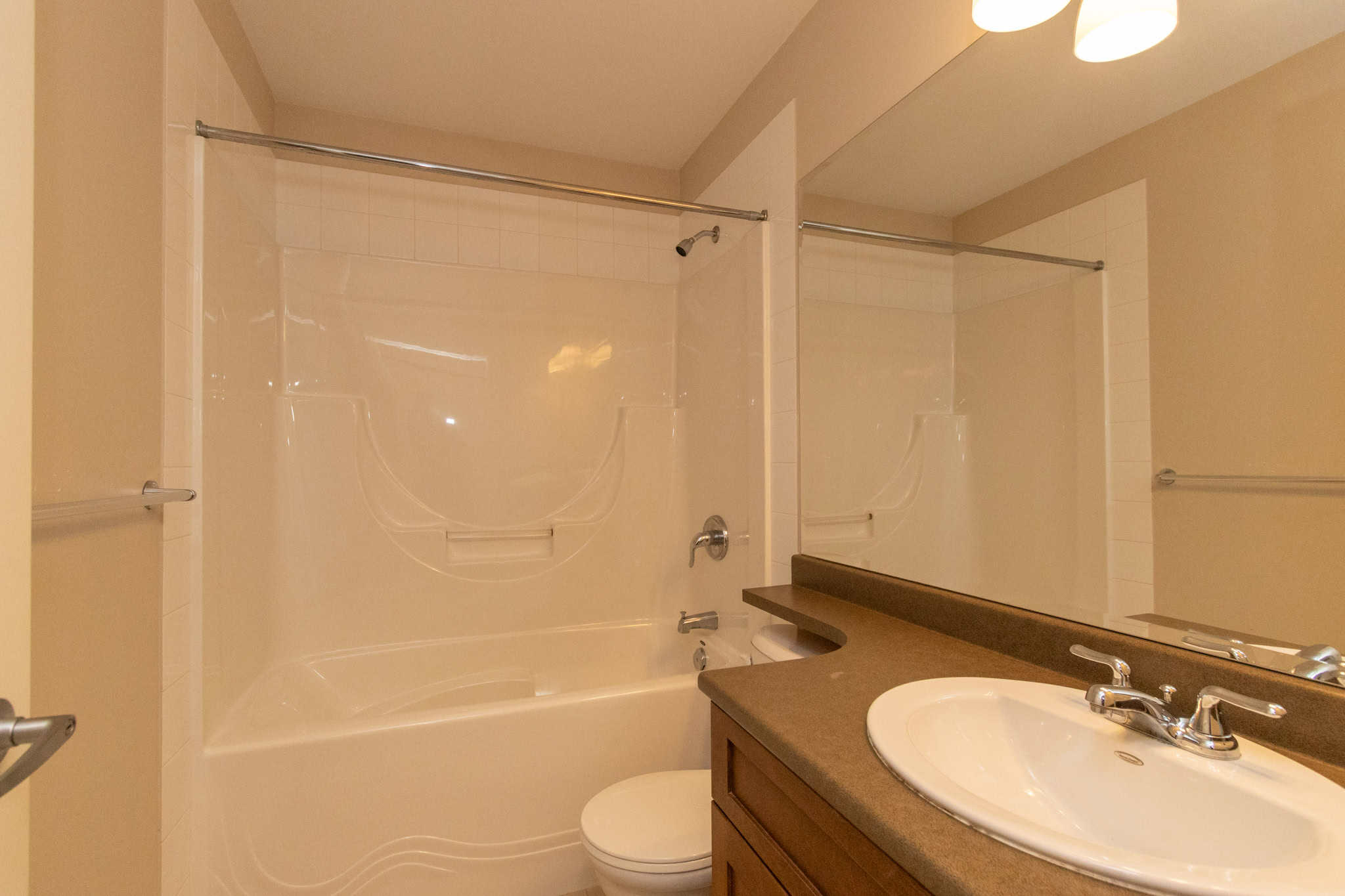 IMG_1813 Modern bathroom with bathtub and shower, wood vanity with sink, and beige tile walls, in a residential property listed by Orca Realty Inc.