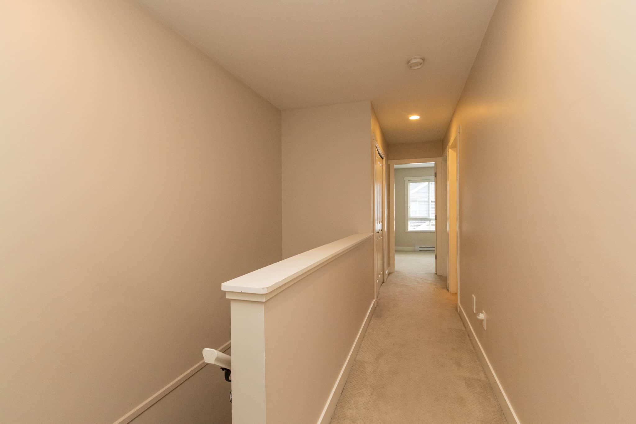 IMG_1823 Bright hallway in a modern residential property, featuring neutral wall tones, carpeting, and natural light from the windows, ideal for buyers seeking elegant homes in the Greater Vancouver area.
