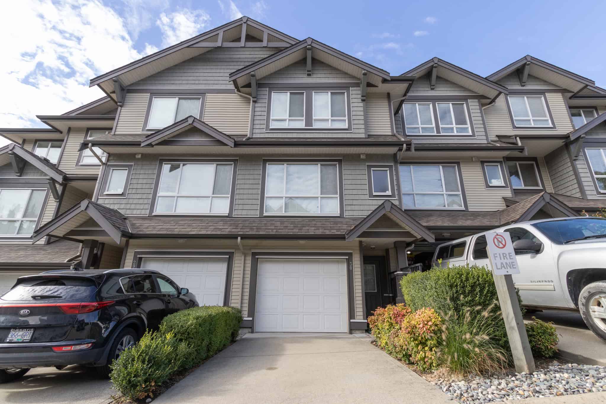 IMG_1847 Modern multi-family townhome with attached garage, landscaped front yard, and contemporary architecture in a vibrant residential community – Orca Realty Inc.