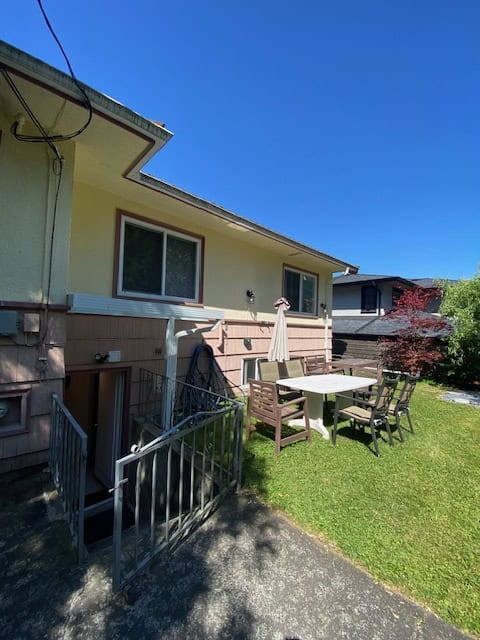 Bright backyard patio of a residential property with outdoor furniture, perfect for family gatherings and relaxation, showcasing Vancouver Island real estate opportunities.