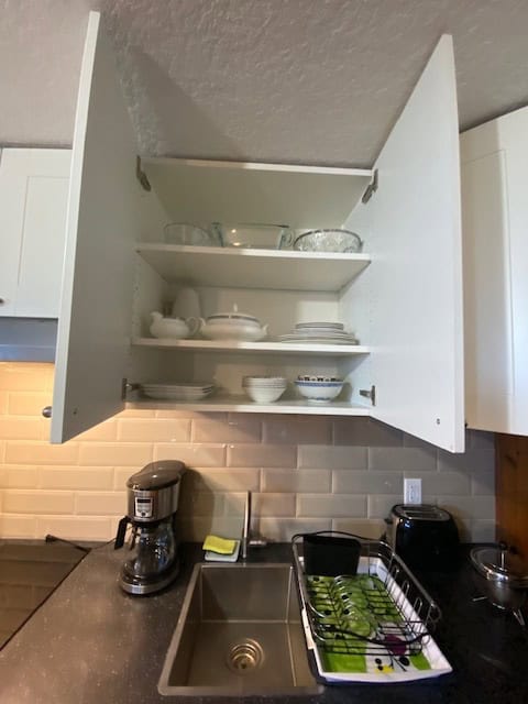 Open kitchen cabinet with dishes and bowls, modern kitchen setup, home interior, organized kitchen shelves, kitchenware, cooking essentials, functional kitchen design.