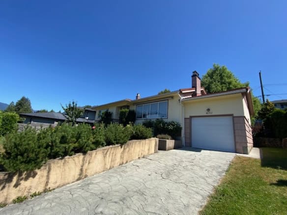 Spacious family home with a large driveway and garage, modern design, situated in a quiet neighbourhood with lush greenery and a well-maintained yard.