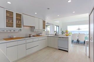 Kitchen with white cabinets and modern design, ocean view, orca reality inc., Vancouver real estate, waterfront property, kitchen renovation, open concept living.